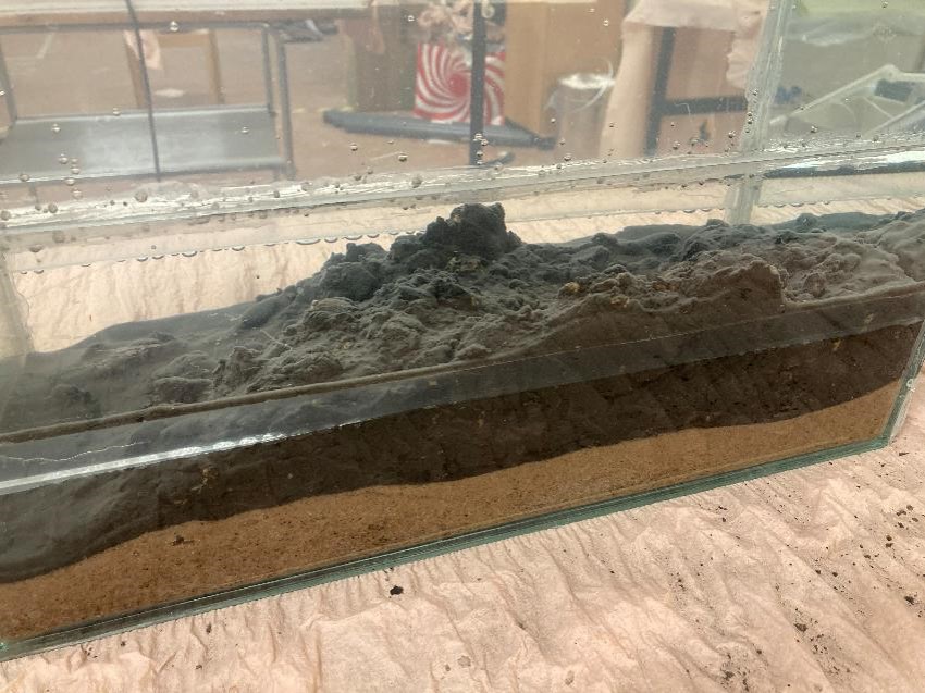 Tunn täckning av biokol/bentonit på ett sandlager, laboratorieförsök i akvarium